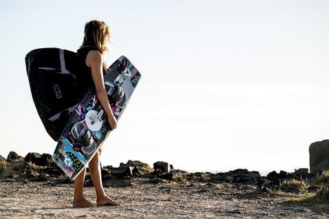 ION Suspect Duffel Bag 90l in black carried along a rocky coastal path