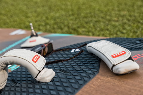 ION Mastbase Protector accessory in off-white and grey placed on a windsurf board deck
