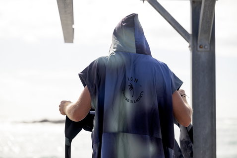 Poncho de troca ION Poncho Select homem em azul-marinho escuro junto ao oceano