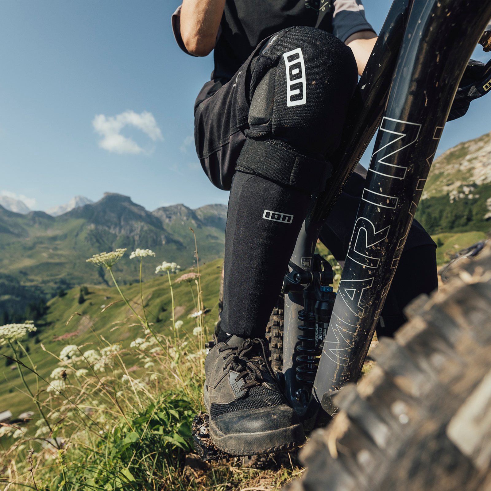 ION S-Pad Amp shin pad in black during mountain biking on an alpine trail