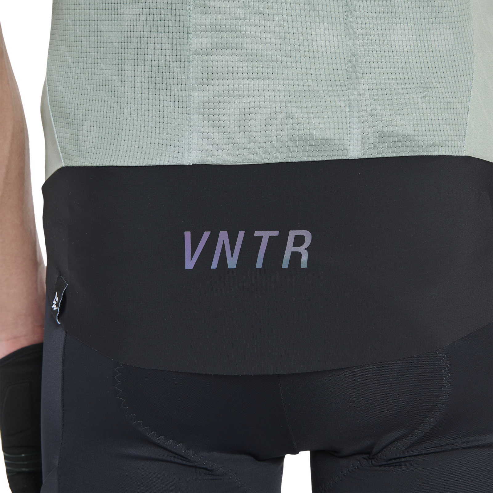 Maillot de cyclisme ION Bike VNTR Amp manches courtes homme en noir et vert sauge, détail dos avec ourlet réfléchissant VNTR