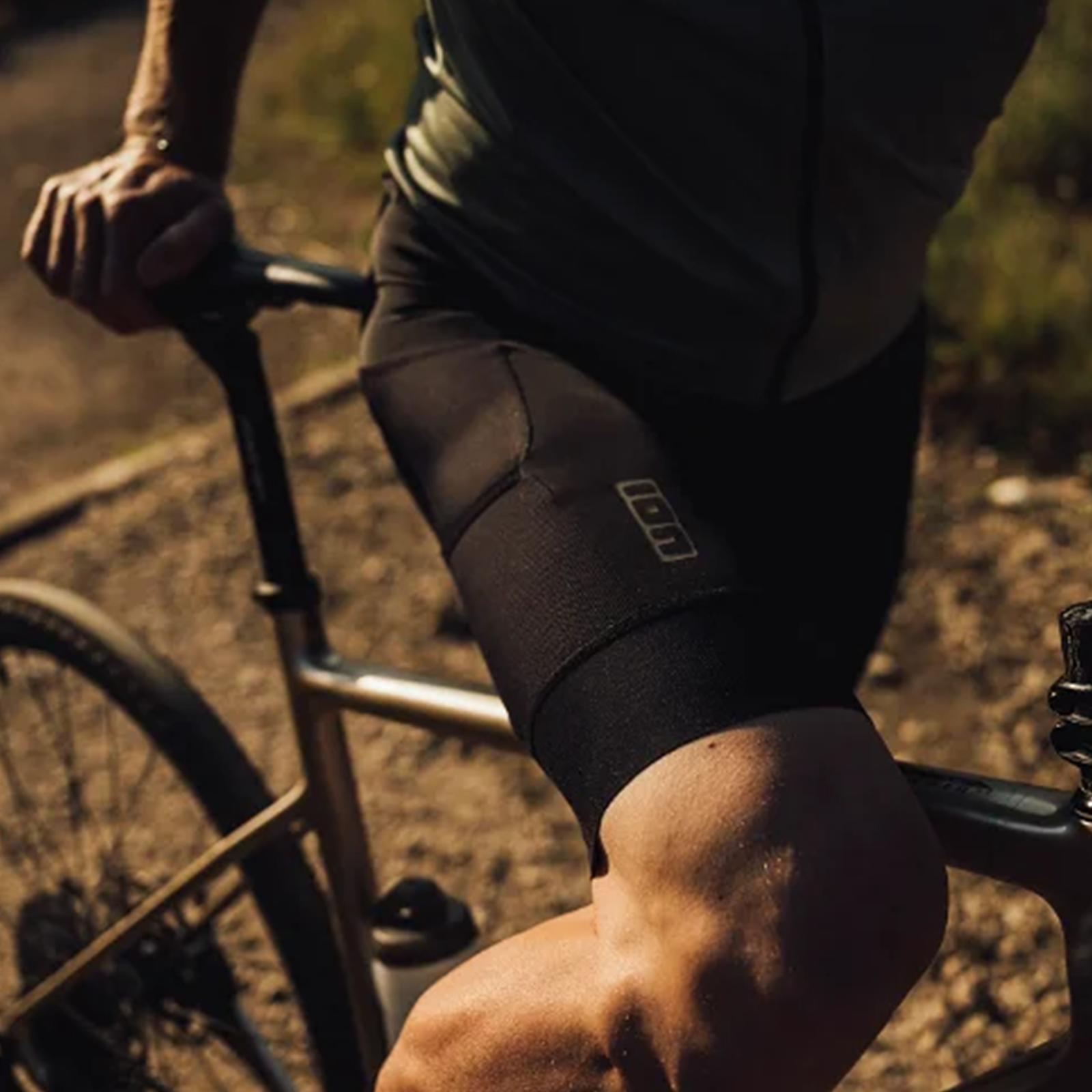 ION VNTR Amp bib shorts men in black during gravel cycling on a dirt trail