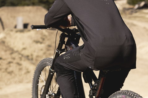 Pantaloni da ciclismo ION Scrub Amp BAT in nero durante il mountain bike su un dirt trail