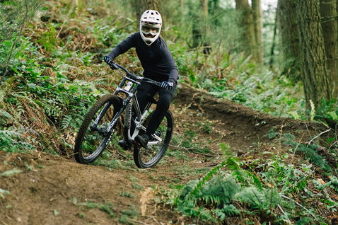 ION Scrub Amp LS women cycling jersey in black during mountain biking in the forest