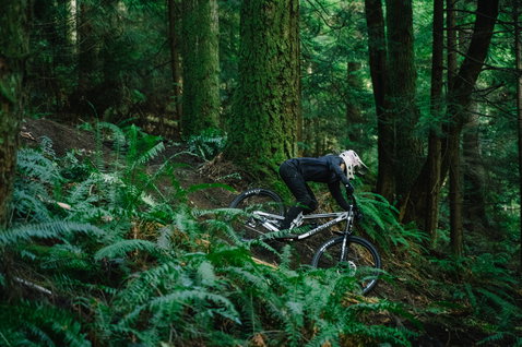 ION Scrub Amp LS women's cycling jersey in black during freeride mountain biking in forest