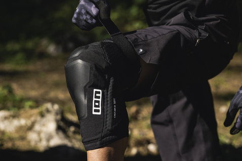 ION K-Pact Amp HD knee pads in black during mountain biking in forest