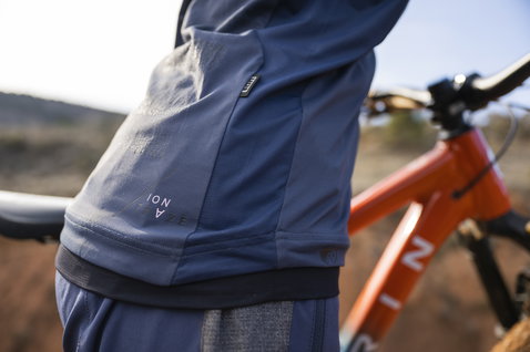 ION Traze Amp LS women's cycling jersey in navy blue during mountain biking on a trail