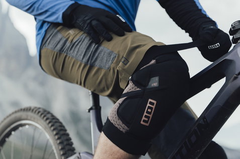 ION Traze Amp AFT cycling shorts men during mountain biking in olive green and grey on alpine trail