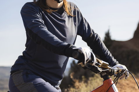 ION Traze Amp AFT women's cycling shorts in dark charcoal during mountain biking on a rocky trail