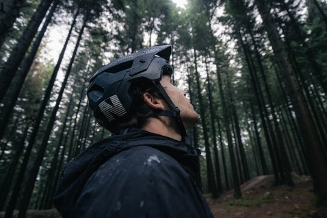 Casque VTT ION Traze Amp MIPS en noir mat pendant le trail en forêt sous la pluie