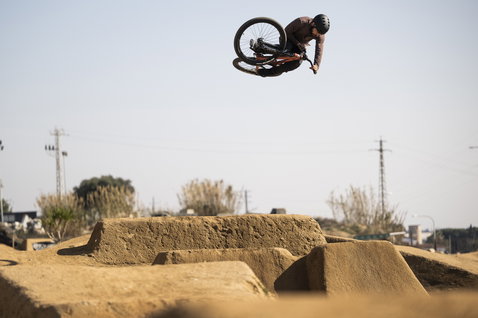 Casco ION Seek durante dirt jumping in un bike park, rider in volo con mountain bike