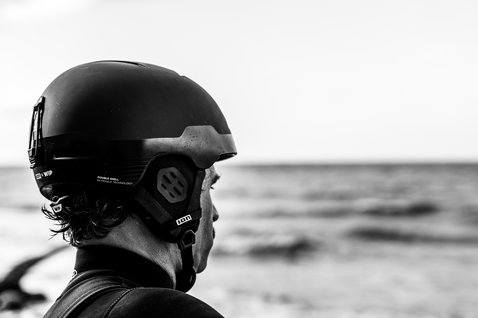 ION Mission Helm beim Kitesurfen am Meer in schwarz, Seitenansicht mit In-Mold-Konstruktion