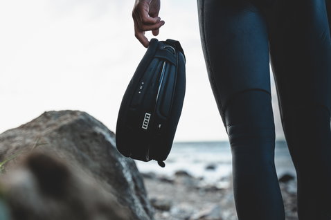 ION Arc waist harness in black with wing hook during wing foiling at the coast