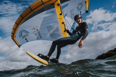 ION Rogue waist harness during wing foiling on the ocean in dark charcoal with CURV® construction