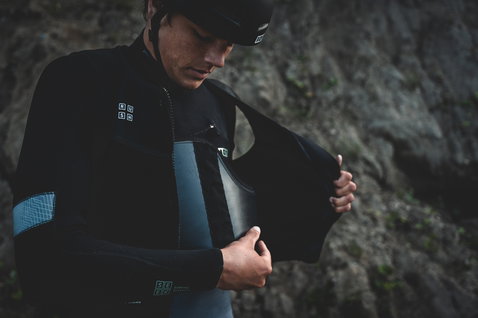 ION Rush veste harnais en noir lors du wing foiling sur côte rocheuse