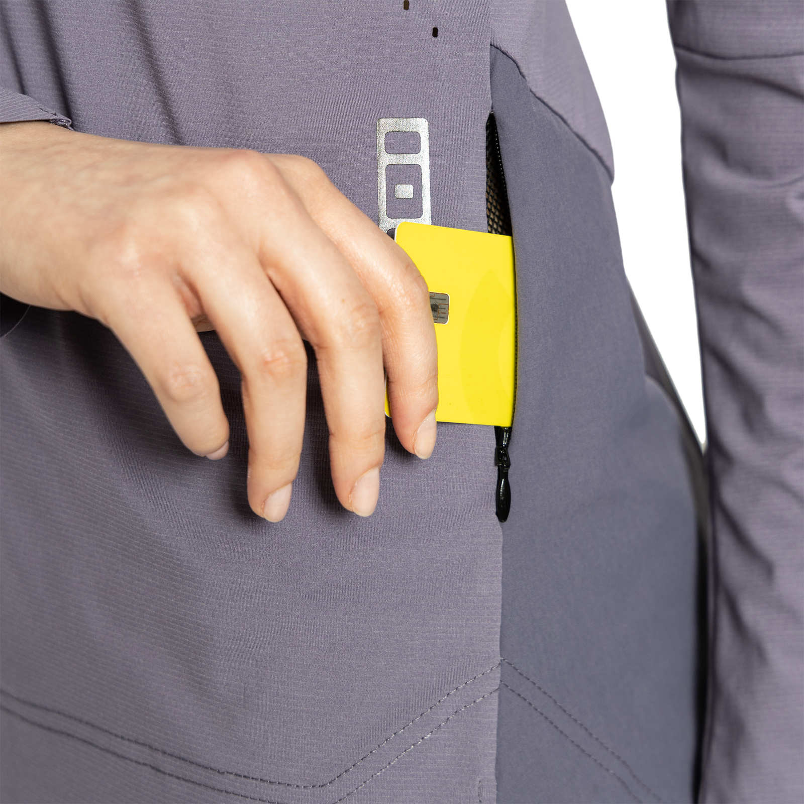 Maillot vélo ION Scrub Amp manches longues femme en gris sombre – détail de la poche zippée ticket