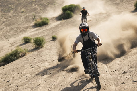 ION Bike Seek Amp dungarees in dark charcoal during mountain biking on sand dunes
