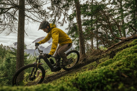 ION Shelter Lite 2.5L cycling jacket in yellow during mountain biking in alpine forest