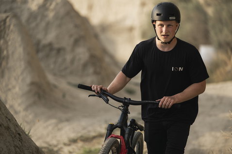 Casco ION Seek in nero indossato da un rider durante il dirt jumping in un bike park