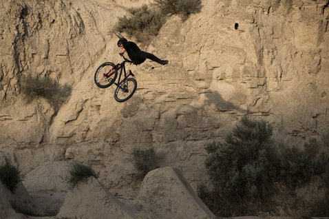 Casco ION Seek durante dirt jump in ambiente di canyon roccioso
