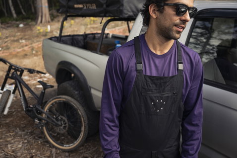 ION Seek cycling dungarees in black during mountain biking in a forest setting