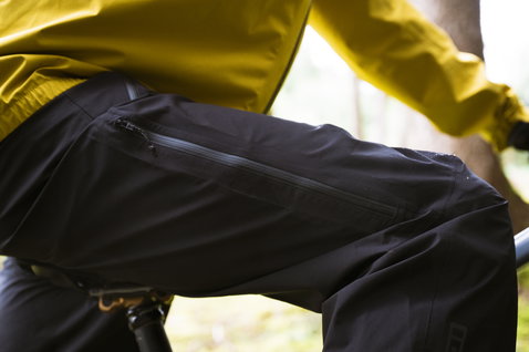 Pantaloni da ciclismo impermeabili ION Shelter Lite 2.5L in nero durante il mountain bike in foresta