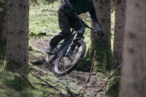 Gilet ciclismo ION Shelter Primaloft Hybrid durante mountain bike in foresta in verde oliva scuro