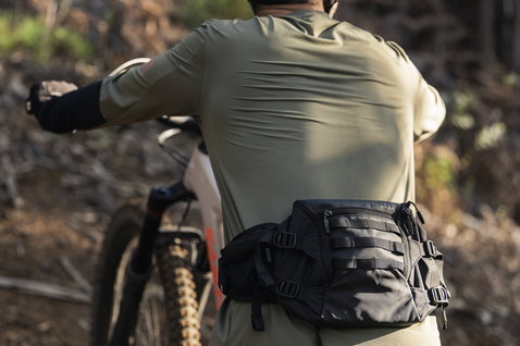 Sac banane ION Traze 3 en noir lors d'une sortie vélo de montagne en forêt