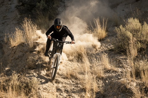ION Scrub Amp BAT long sleeve cycling jersey in black during freeride mountain biking on dusty trail