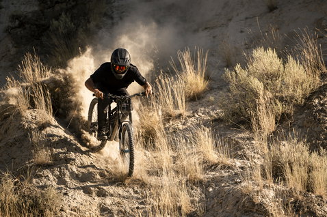 ION Scrub Amp Bikehose beim Freeride Mountainbiken auf staubigem Wüstenpfad in schwarz