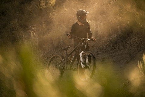 ION Bike Scrub Amp LS BAT men's long-sleeve cycling jersey in black during mountain biking on a dusty trail