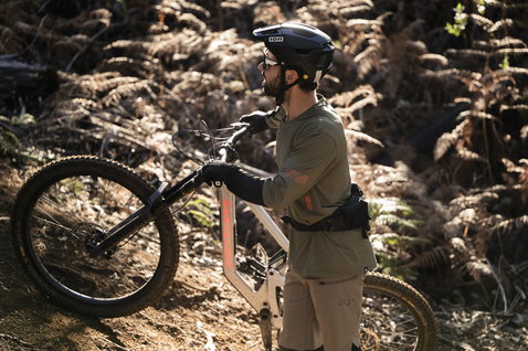 ION Traze Amp LS AFT Langarm-Bikejacke in oliv beim Mountainbiken im Wald