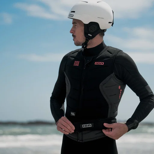 ION Hip Belt in black with quick-release buckle, worn at the beach over impact protection gear