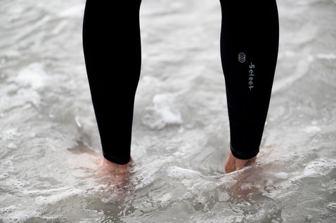 ION Seek Select 5/4mm front-zip fullsuit wetsuit in black during kitesurfing in shallow surf