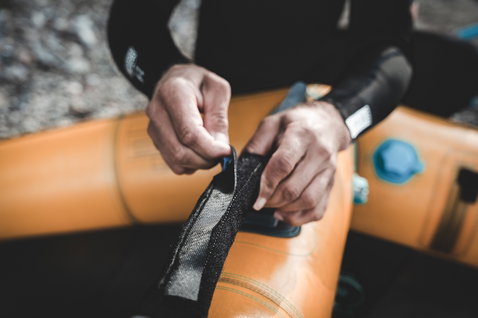 ION Wing Handle fixé sur une aile de foil orange lors de la préparation au wing foiling en extérieur