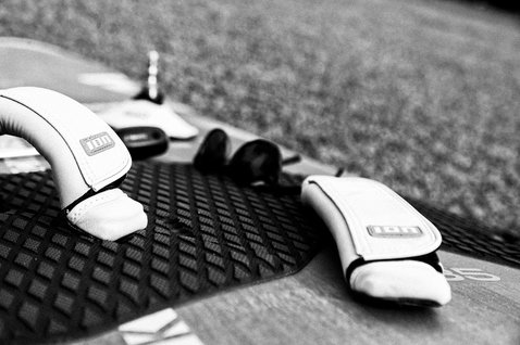 Footstrap windsurf ION con imbottitura in neoprene e plug antirotazione su deck della tavola in nero e bianco