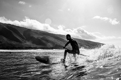 ION Wing SUP Board Leash Core Coiled Knee durante il surf sulle onde a Maui