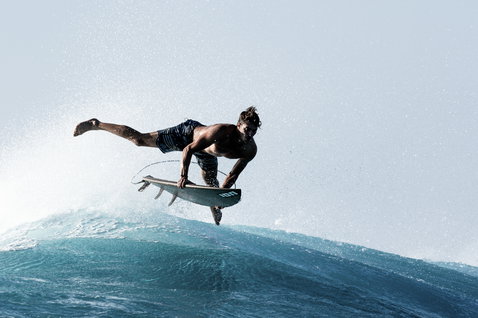 ION Surf Leash Core Ankle during wave riding with surfer performing aerial on the ocean