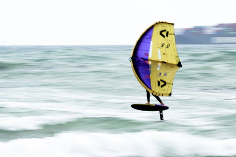 ION Wing Board Leash Core Coiled Hip Release durante wing foiling sull'oceano aperto