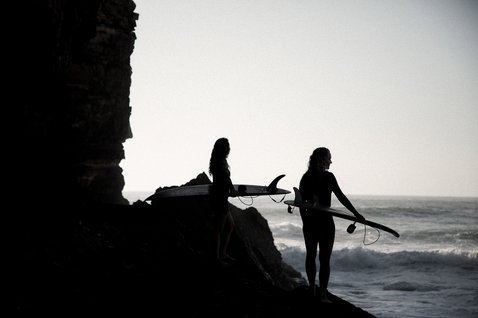 ION Neo Zip Top 2/1 LS Skin donna top in neoprene durante surf su onde in costa rocciosa