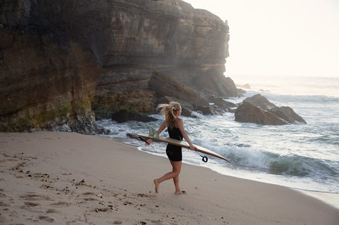 ION Monoshorty 0,5 mm Shorty-Neoprenanzug Damen in schwarz beim Wellenreiten am Strand