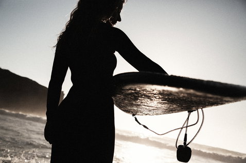 ION Core Ankle surf leash during wave surfing at the beach in backlit golden hour