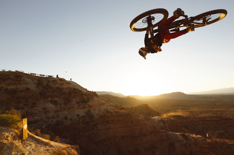 ION Ionic LT men's bike pants in red during freeride mountain biking in desert terrain