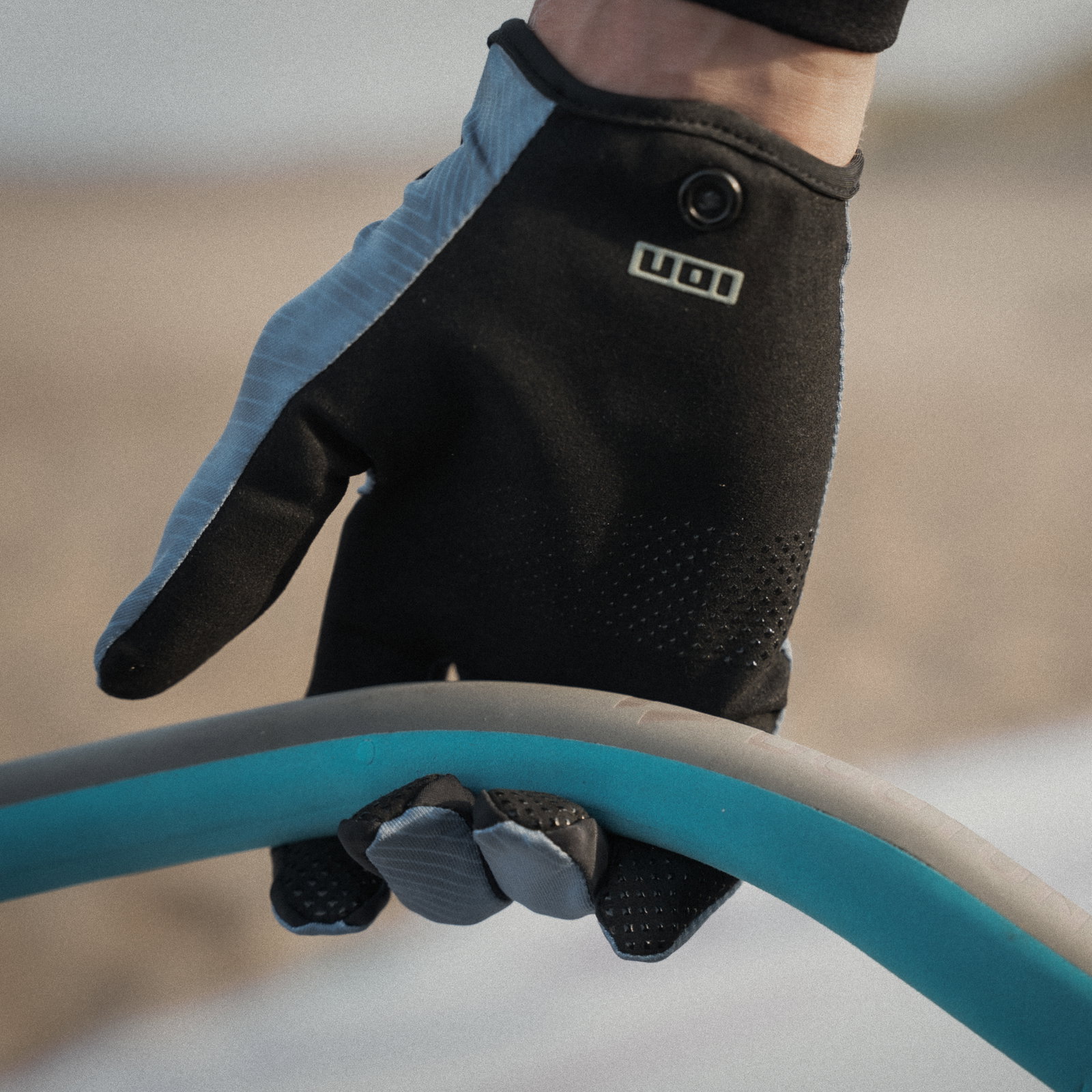 Gant ION Amara doigts complets en noir et bleu ardoise lors d'une session de windsurf