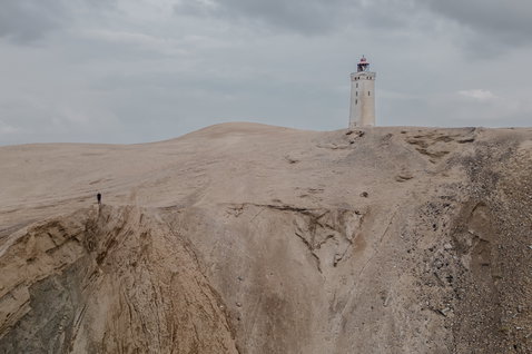 ION Neo Bommel Beanie beim Freeriden an der Küste mit Leuchtturm bei bedecktem Himmel