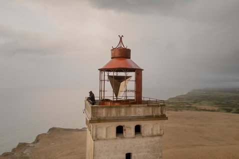 ION TEC Beanie beim Kitesurfen an der Küste mit Blick auf Leuchtturm und Meereslandschaft