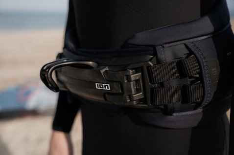 Harnais de taille ION Rival en noir avec spreader bar lors du windsurf sur la plage