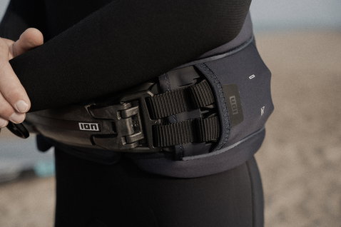 Harnais de taille ION Rival en noir avec barre Spectre Bar 2 lors d'une session windsurf sur la plage