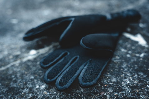 Gants en néoprène ION Neo Gloves 4/2 unisexe en noir sur fond de pierre