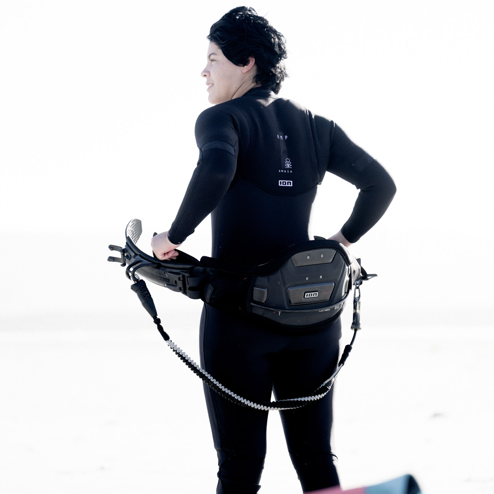 ION Nova waist harness in black with Ergo Pad back support during kitesurfing at the beach